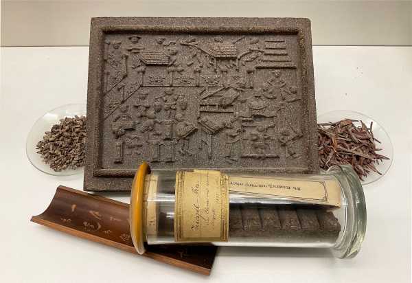 Chinese brick tea 1895 with bamboo spoon, tea samples and tea brick in background