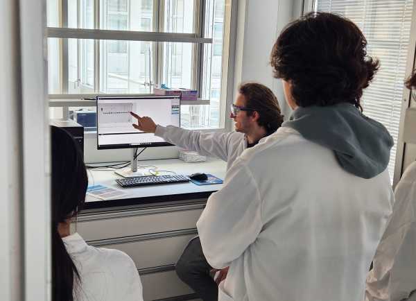 students listing to a doctoral student in the Yamauchi Lab